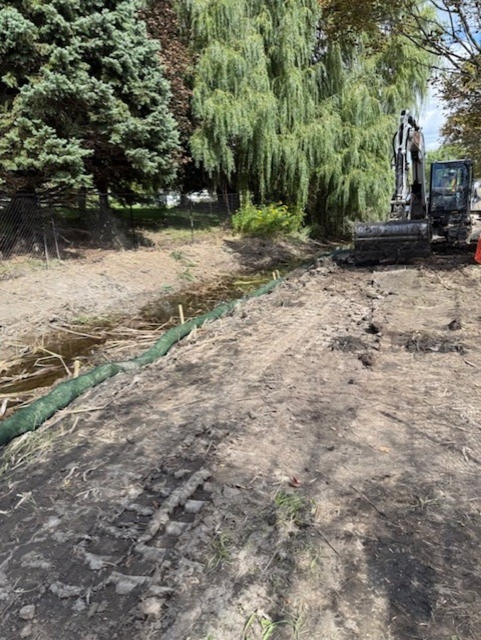Excavator working along the Evergreen Estate watercourse with coir log erosion control installed